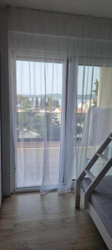 a room with a large window with white curtains at Summer Park Residence Peljesac in Orebić