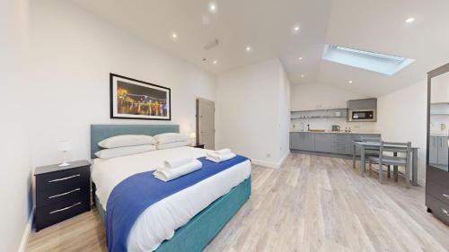 a bedroom with a large bed and a kitchen at Bicester Court in Bicester