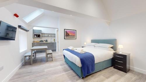 a bedroom with a bed and a desk and a kitchen at Bicester Court in Bicester