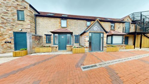 a brick building with blue doors on a brick driveway at Bicester Court in Bicester