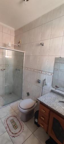 a bathroom with a toilet and a shower and a sink at Casa de temporada Passos MG in Passos