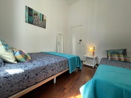 a bedroom with two beds and a table with a lamp at Centric Rooms Ghotic in Barcelona