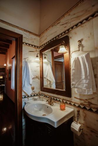 a bathroom with a sink and a mirror at PanThea Stone Villa in Aígio
