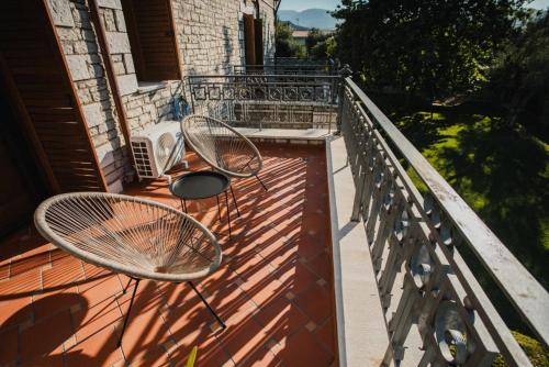 a balcony with two chairs and a table at PanThea Stone Villa in Aígio