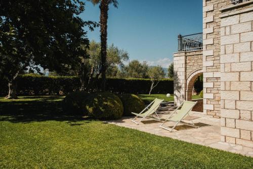 two chairs sitting on a patio in a yard at PanThea Stone Villa in Aígio