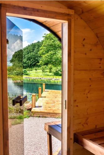 a door to a cabin with a view of a lake at The Big Barn in Kidwelly