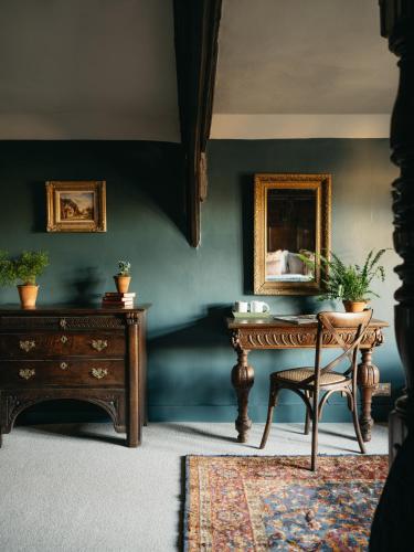 a room with a table and a chair and a mirror at Boys Hall in Willesborough