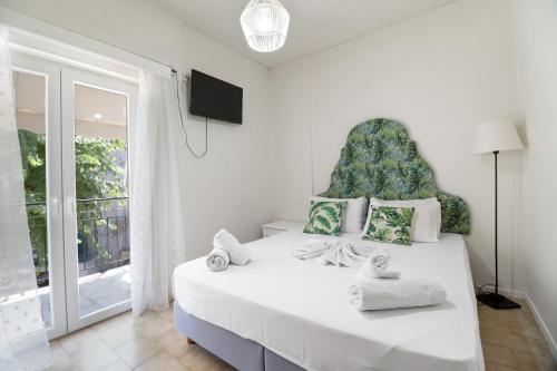 ニキアナにあるM4 roomの大きな窓のある大きな白いベッドのある寝室