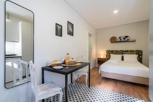 a bedroom with a bed and a desk with a table at Oporto Seaside Village - Casa Savana in Matosinhos
