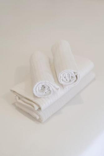 a pile of white towels on a white background at Oporto Seaside Village - Casa Savana in Matosinhos