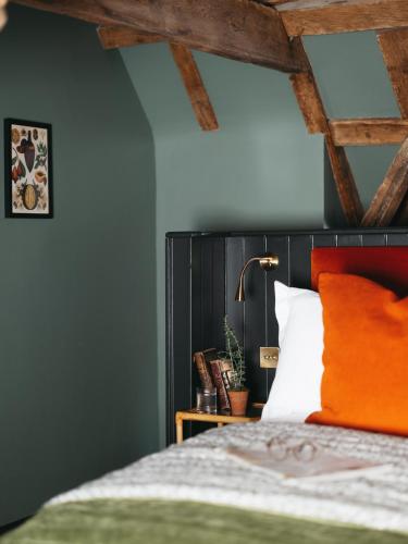 a bedroom with a bed with an orange headboard at Boys Hall in Willesborough