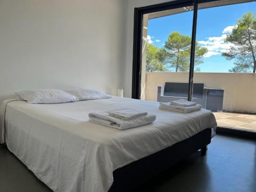 une chambre avec un grand lit avec des serviettes dessus dans l'établissement Superbe et spacieuse propriété avec piscine et spa, à Saint-Gély-du-Fesc