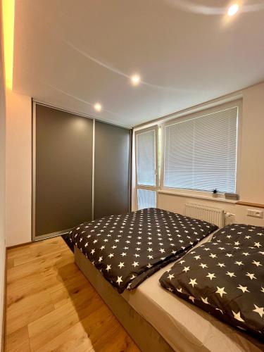 a bedroom with a bed and a large window at Rovník in Košice