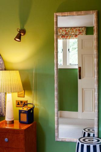 a mirror in a room with a green wall at Boys Hall in Willesborough