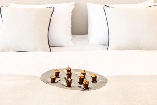 a tray of four gold figurines on a bed at Apeiro City Avant-garde Hotel in Sarajevo