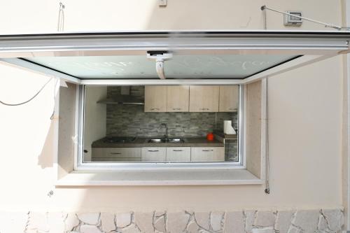 a window in a room with a kitchen behind it at Le Case Di Nonna Angela in Matera