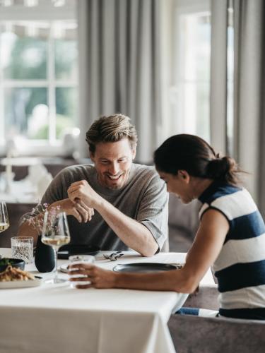 a man and a woman sitting at a table at Alpina Alpendorf in Sankt Johann im Pongau
