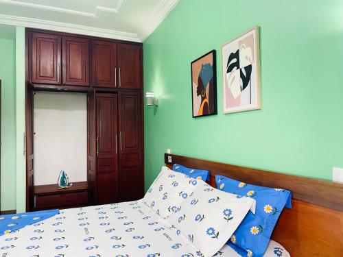 a bedroom with green walls and a bed with a wooden headboard at Matera YameHome in Yaoundé