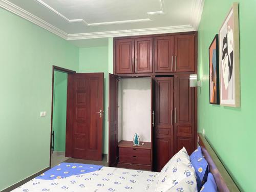 a bedroom with a bed and wooden cabinets at Matera YameHome in Yaoundé