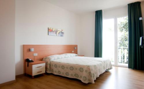a bedroom with a bed and a large window at Hotel Rado in Lido di Jesolo