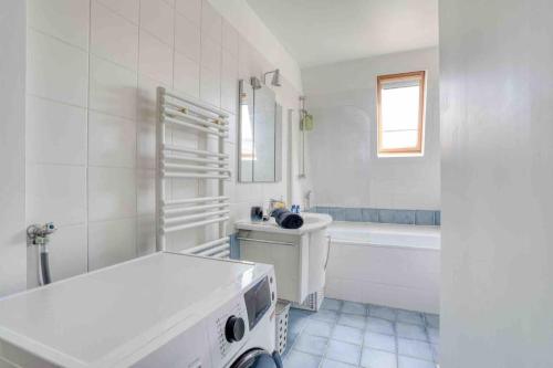 une salle de bain blanche avec un lavabo et une baignoire dans l'établissement Le Victor Hugo, à Paris