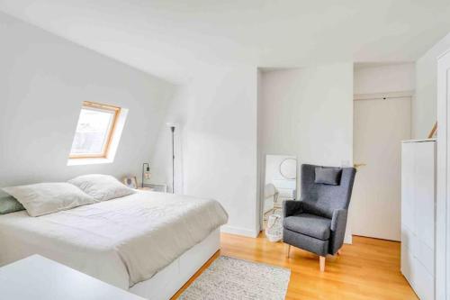 une chambre blanche avec un lit et une chaise dans l'établissement Le Victor Hugo, à Paris