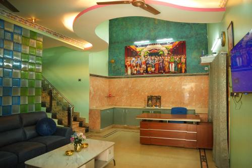a living room with a couch and a painting on the wall at The HR STAY INN TIRUPATI - LUXURY HOMESTAY - NEAR ALIPIRI BUS STAND AND KAPILATEERTHAM - 24 HRS HOT WATER-150 MBPS SPEED FREE WIFI & ALL OTT APPS in Tirupati