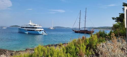 a large boat in the water with two boats at Summer Park Residence Peljesac in Orebić