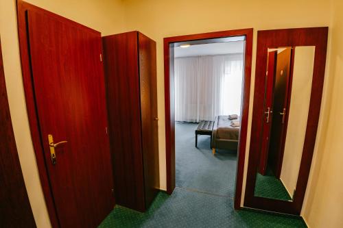 a hallway with two doors and a room with a bed at Greenwood hotel in Smokovce