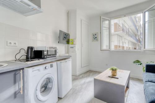 - une cuisine blanche avec un lave-linge dans le salon dans l'établissement Le studio duret 1, à Paris