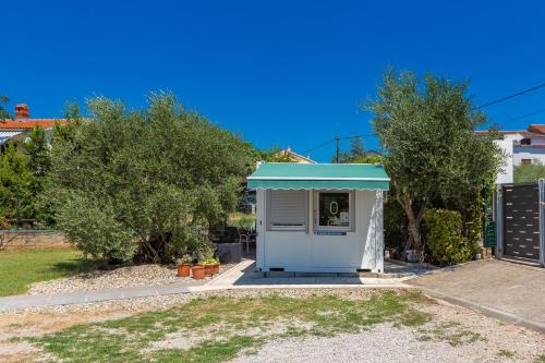 a small shed with a green roof in a yard at Bellona in Malinska