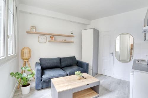 un salon avec un canapé bleu et une table dans l'établissement Le studio duret 1, à Paris