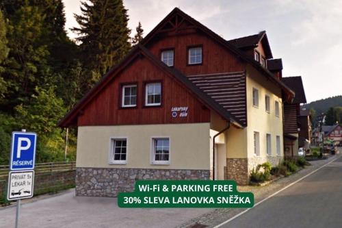 a house with a parking sign in front of it at Apartmány Lékařský dům in Pec pod Sněžkou