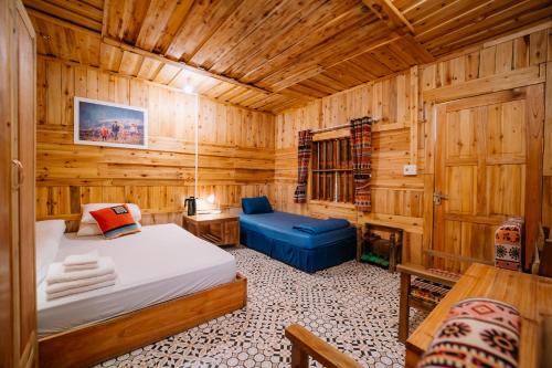 a bedroom with a bed in a wooden room at Ha Giang Xanh Retreat - Trekking, Tour, Motorbike Rental in Ha Giang