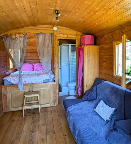 - une chambre avec un canapé et un lit dans une cabine dans l'établissement Roulotte du Mas Rondole, à Saillagouse