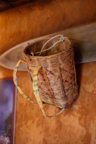 a wicker basket with a rope hanging on a wall at Ha Giang Xanh Retreat - Trekking, Tour, Motorbike Rental in Ha Giang