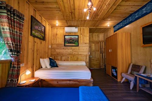 a bedroom with a bed in a wooden room at Ha Giang Xanh Retreat - Trekking, Tour, Motorbike Rental in Ha Giang