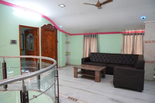 a living room with a couch and a table at The HR STAY INN TIRUPATI - LUXURY HOMESTAY - NEAR ALIPIRI BUS STAND AND KAPILATEERTHAM - 24 HRS HOT WATER-150 MBPS SPEED FREE WIFI & ALL OTT APPS in Tirupati