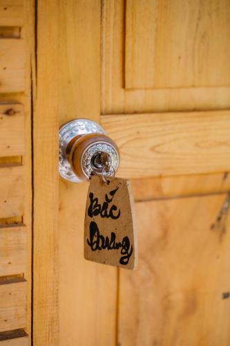 a tag hanging from a door knob of a wooden door at Ha Giang Xanh Retreat - Trekking, Tour, Motorbike Rental in Ha Giang