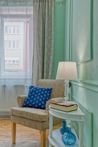 a chair with a pillow and a table with a lamp at RASL Residens, apartmán s terasou in Jihlava