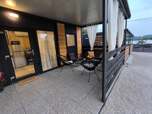 トゥラニにあるLuxury Ondina- Beachfront Retreatの家の上の椅子とテーブルのあるパティオ