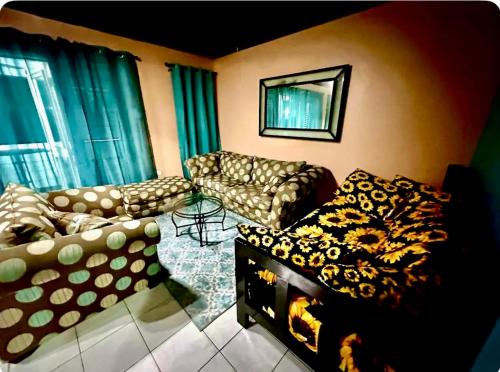 a living room with two couches and a table at Seaside 2 Bedroom Oasis at 7 Miles Beach, Negril, Point Village in Negril