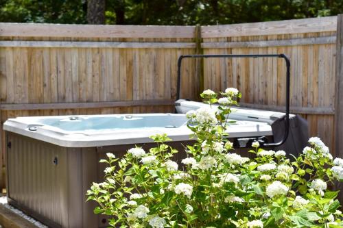 una bañera de hidromasaje en un jardín junto a una valla en Hot Tub Central A C Dog Friendly, en Eastham