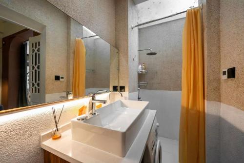 un bagno con lavandino, specchio e doccia di 上海小胖纸民宿-武康大楼3店-老吉士 a Shanghai