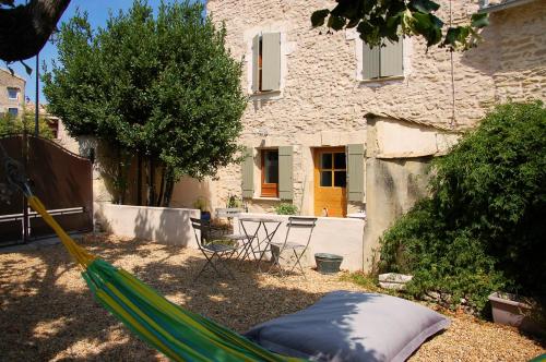 a hammock in a yard with a house at Apres La Sieste in Saint-Laurent-des-Arbres