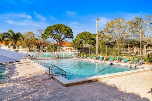 a large swimming pool with chairs at Spacious Shorewalk 2B-2B Condo near Anna Maria Island, Beaches & IMG Academy in Bradenton