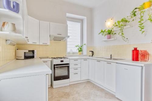 a white kitchen with white cabinets and appliances at RASL Residens, apartmán s terasou in Jihlava