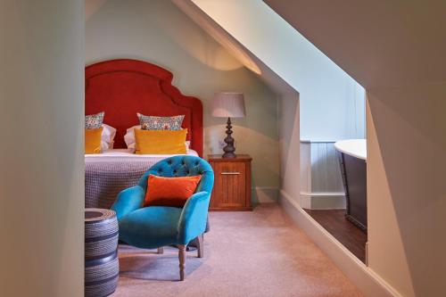a bedroom with a bed and a blue chair at Hotel Du Vin Edinburgh in Edinburgh