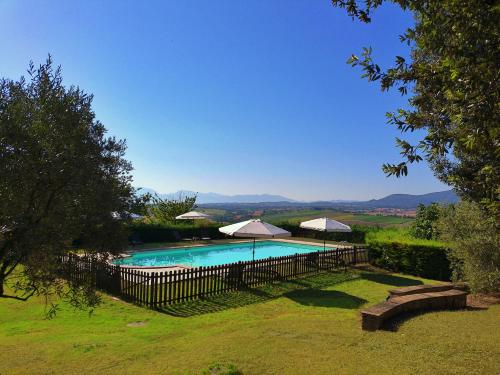 a swimming pool with umbrellas in a yard at La Collina dei Venti in Gualdo Cattaneo