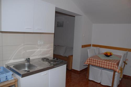 Una pequeña cocina con un fregadero y una mesa. en Apartments Kate, en Senj